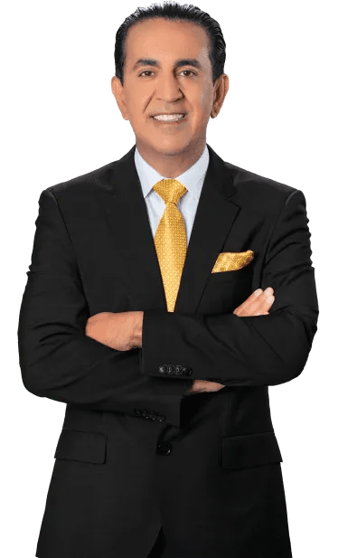 A personal injury lawyer in a black suit with a yellow tie and matching pocket square stands with his arms crossed, smiling, against a plain white background.