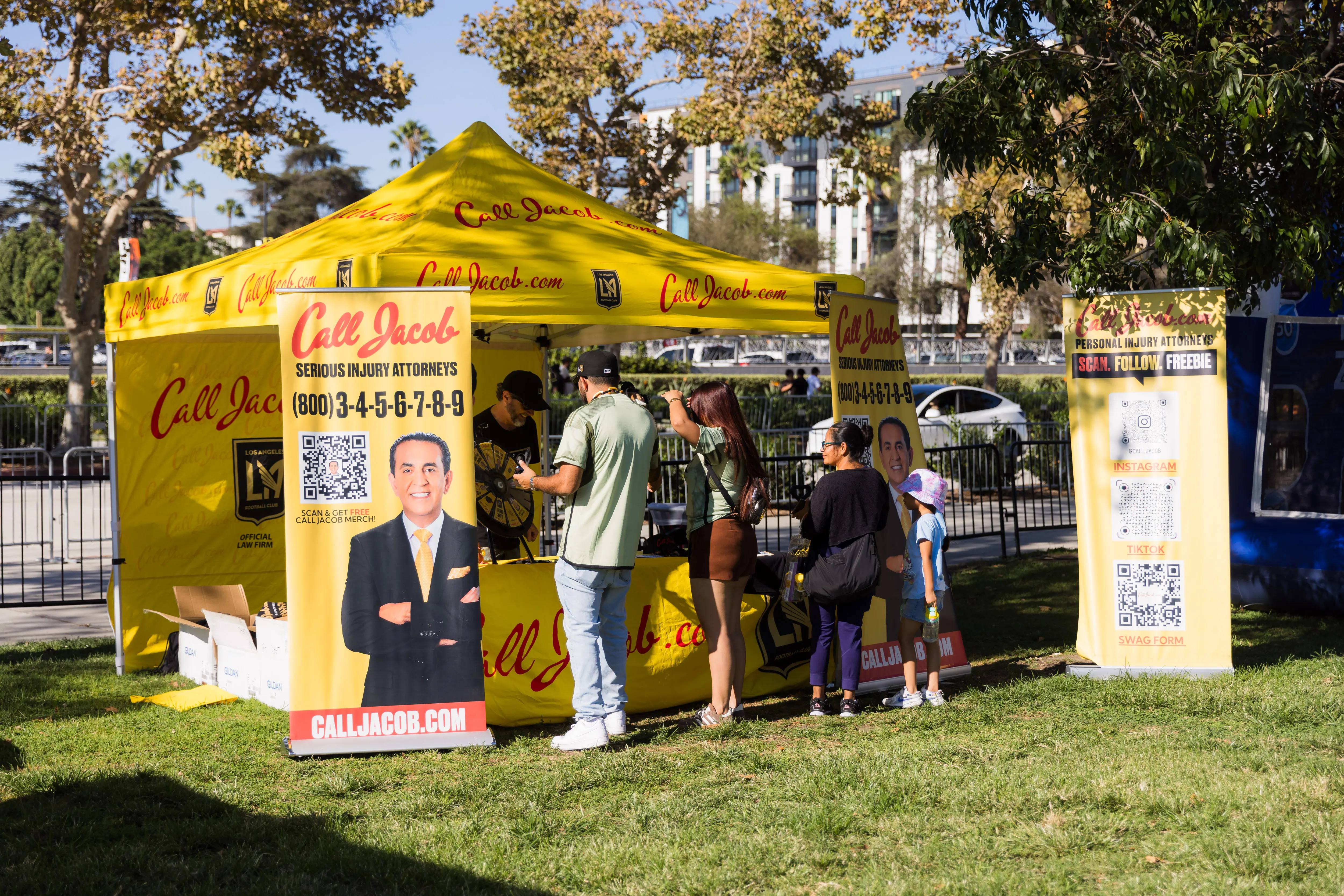 Fans visit the yellow Call Jacob booth at an LAFC community event