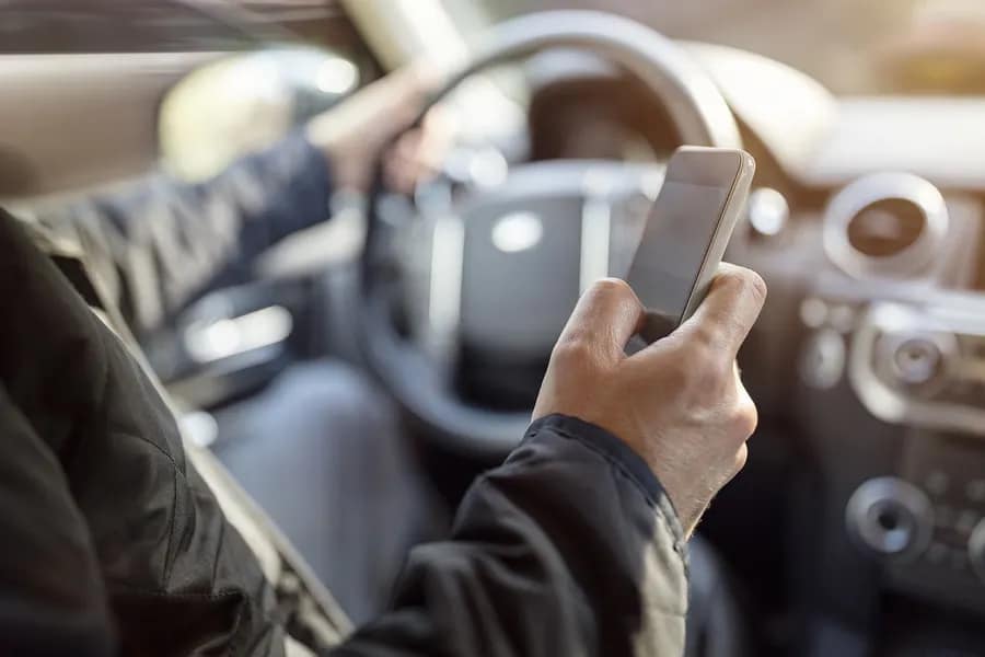 Using a phone in a car texting while driving concept for danger