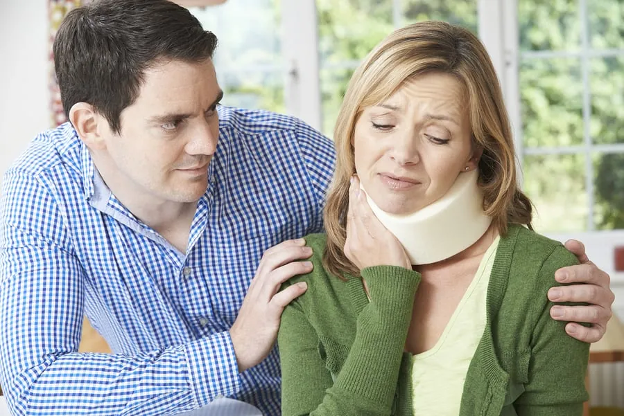 A husband comforting his wife after a neck injury