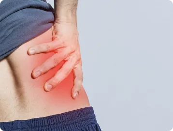 A person clutching their lower back, with a red area highlighting pain or discomfort in the lower back or hip region, possibly indicating a personal injury that may require consultation with a personal injury attorney.
