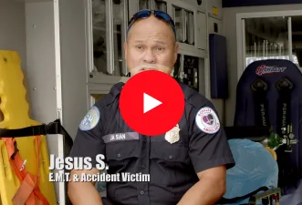 A man in an EMT uniform sits inside an ambulance. Text on the image reads, "Jesus S. E.M.T. & Accident Victim." A large red play button covers the center, hinting at a personal injury story linked to car accidents.