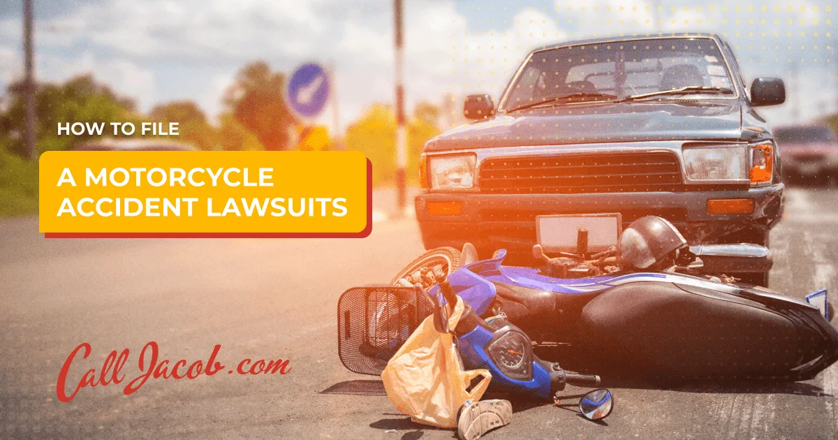 A damaged blue motorcycle lies on its side in front of a car at an intersection, with text overlay: “How to file a motorcycle accident lawsuits. CallJacob.com.” The image suggests personal injury attorney services for accident victims.