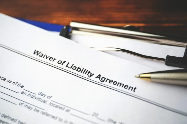 A close-up of a "Waiver of Liability Agreement" document on a clipboard with a pen resting on top, ready to be filled out and signed—an important step often reviewed by lawyers after car accidents.