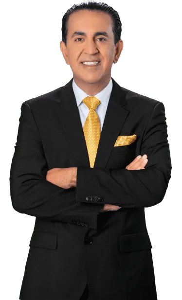 A personal injury lawyer in a black suit with a yellow tie and matching pocket square stands with his arms crossed, smiling, against a plain white background.