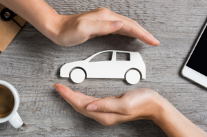 hands-holding-car-paper-cut-out
