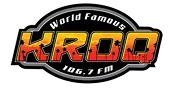 Logo for KROQ 106.7 FM with the words "World Famous" above large orange and yellow "KROQ" lettering, featuring a city skyline and star details inside the letters.