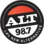 A circular logo for ALT 98.7, a radio station, featuring bold white text "ALT" and "98.7" with the tagline "LA's New Alternative" on a black, red, and white background.