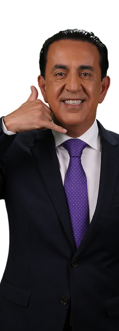 A man in a suit and purple tie smiles while holding his hand to his face in a “call me” gesture, embodying el mero mero confidence against a plain white background.