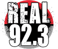 The logo for radio station Real 92.3 features bold, distressed white text reading "REAL 92.3" against a red and black circular background.