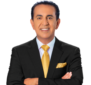 A man with dark hair wearing a black suit, white shirt, and yellow patterned tie stands with arms crossed, smiling confidently at the camera—exuding the professionalism of a Los Angeles Personal Injury Lawyer—against a plain white background.